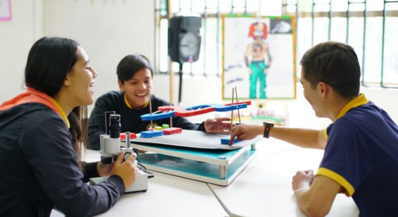 tres estudiantes con sonrisa en su rostro aprender sobre ADN usando un microscopio una maqueta con un modelo de ADN.